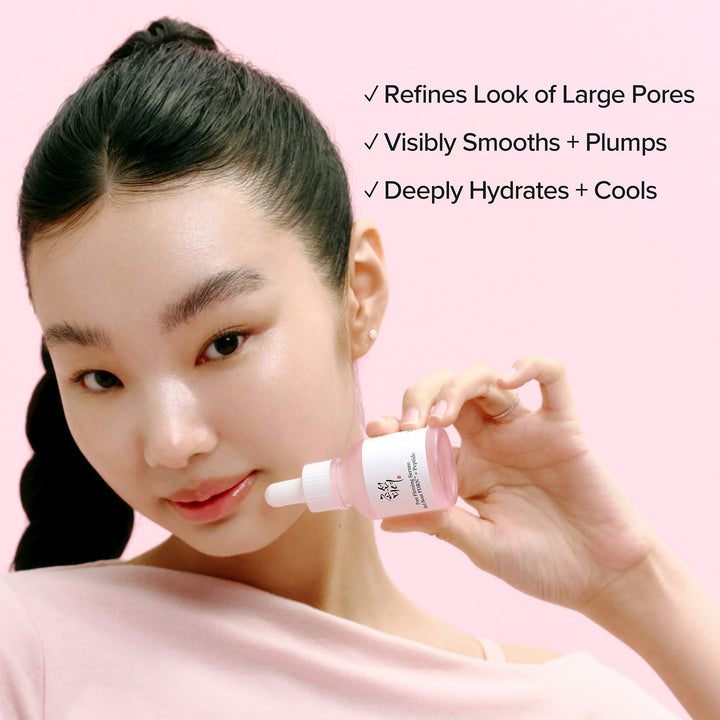 Woman holding a BEAUTY OF JOSEON Pore Firming Serum with product benefits listed on a pink background