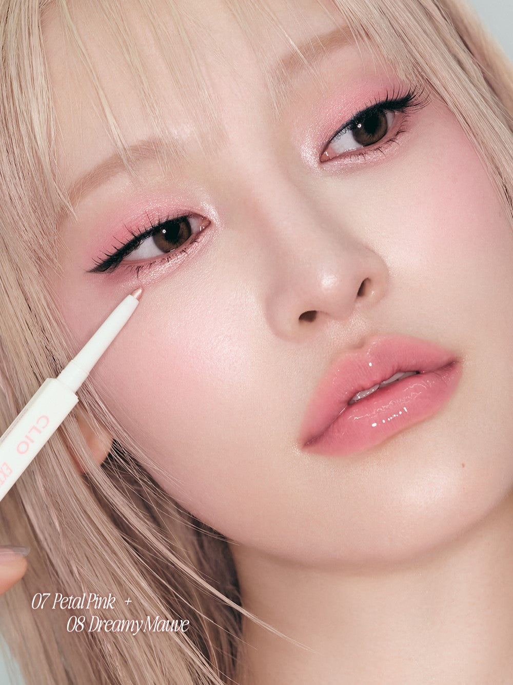 Close-up of a person applying eyeliner with a pencil, focusing on the eye area.