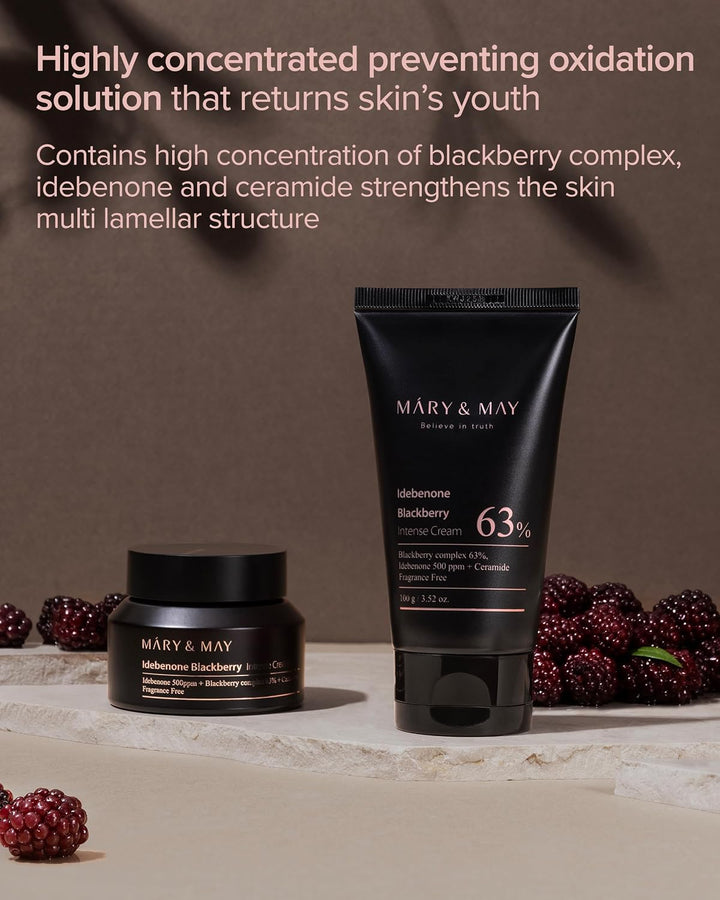 Mary & May skincare products shown on a beige surface against a brown backdrop, with blackberry props and promotional text at the top. The set includes a blackberry cream jar and a blackberry cream tube labeled 63% with visible Mary & May branding.
