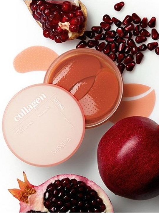 A round cosmetic jar labeled 'collagen lifting' with the lid off, showing a peach-colored patch under-eye gel, styled with pomegranate halves and whole pomegranates on a white background.
